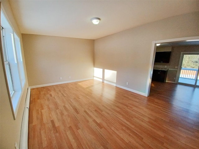 empty room featuring hardwood / wood-style floors and baseboard heating