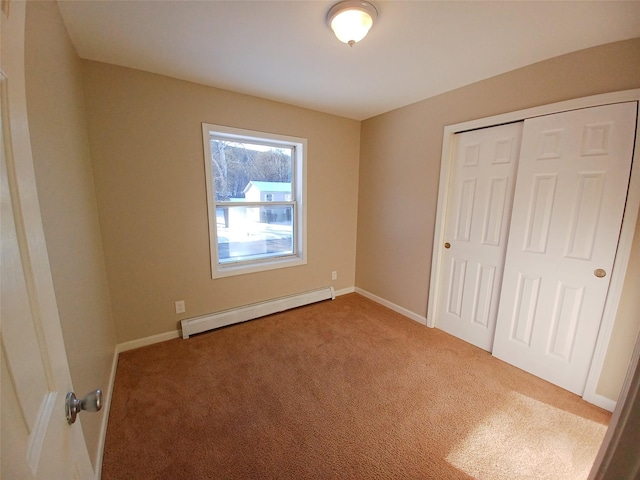 unfurnished bedroom featuring a baseboard radiator, a closet, and carpet flooring