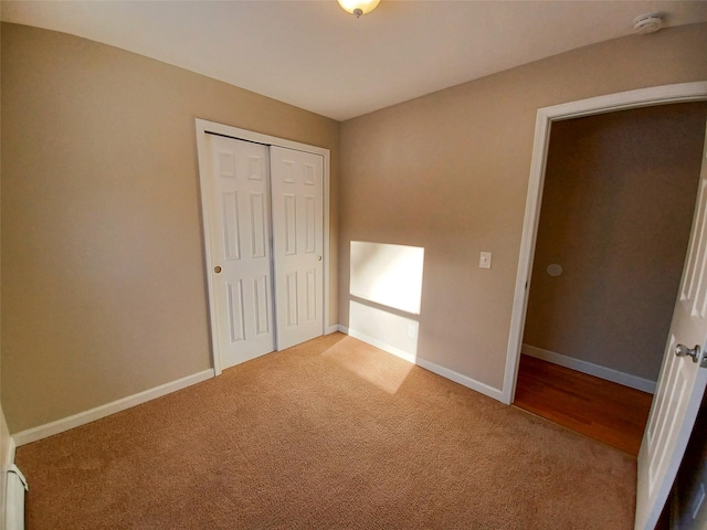 unfurnished bedroom featuring light colored carpet and a closet