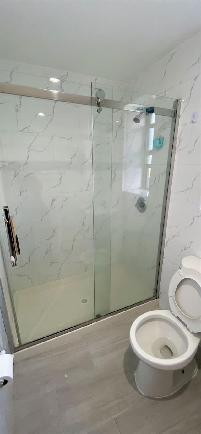 bathroom featuring toilet and an enclosed shower