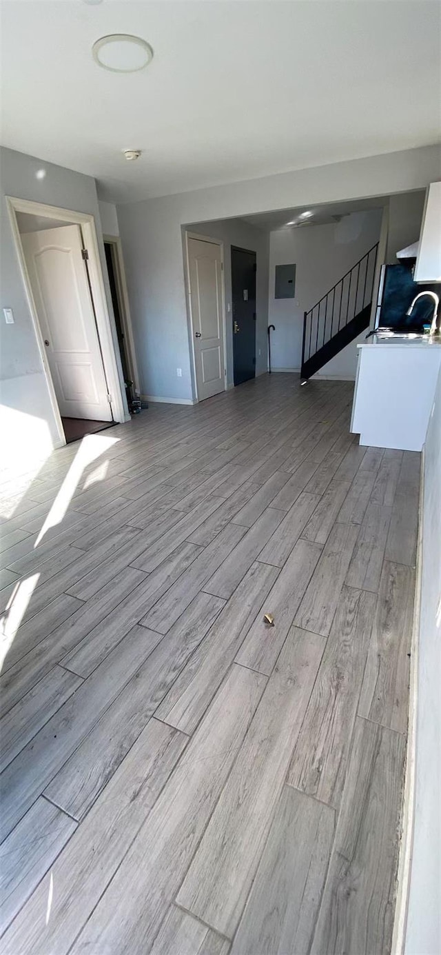 unfurnished living room featuring light hardwood / wood-style flooring and electric panel