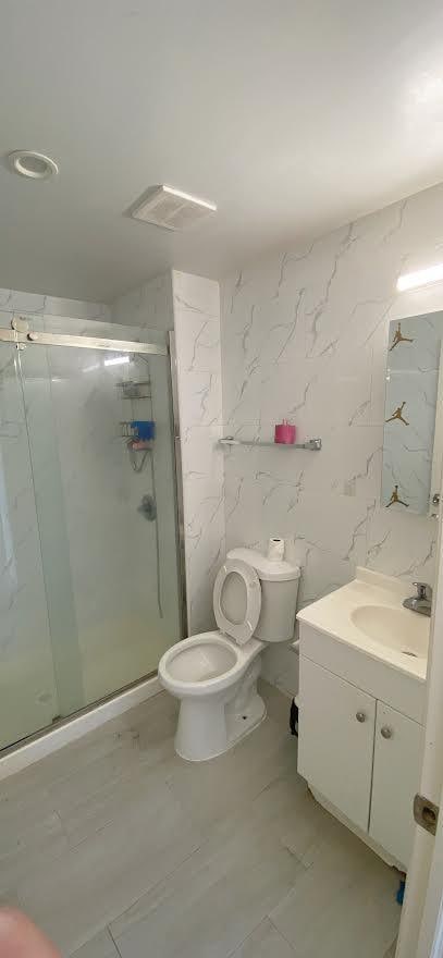 full bath with visible vents, a shower stall, toilet, marble finish floor, and vanity