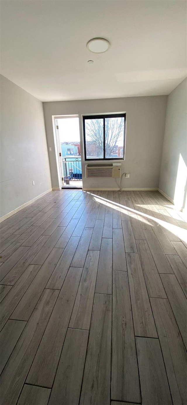 unfurnished room with baseboards and wood finished floors