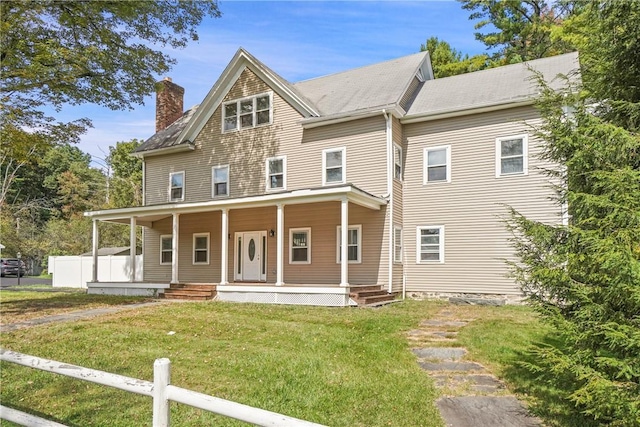 view of front of home with covered porch and a front lawn