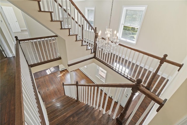 staircase featuring a chandelier and hardwood / wood-style floors