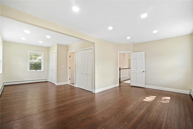 unfurnished room with dark hardwood / wood-style flooring and baseboard heating