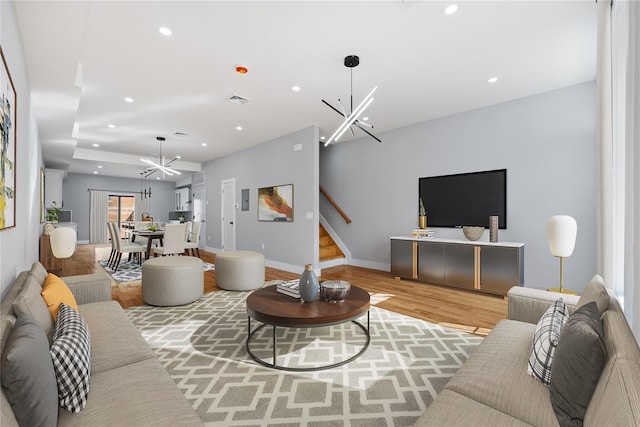 living room featuring an inviting chandelier and hardwood / wood-style floors