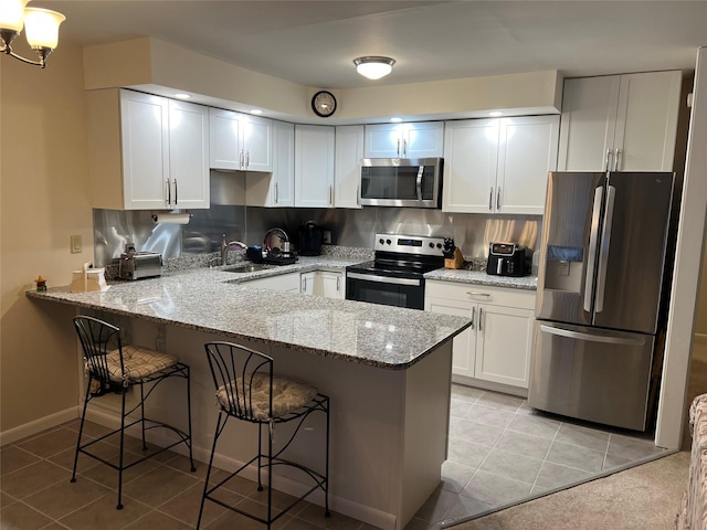 kitchen with stainless steel appliances, a sink, a peninsula, and tasteful backsplash