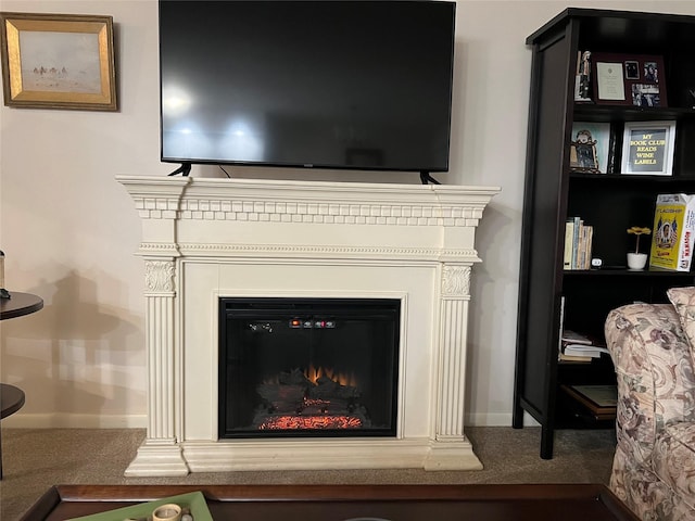 interior details with carpet floors, a glass covered fireplace, and baseboards