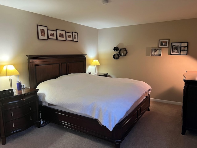 bedroom with baseboards and dark colored carpet