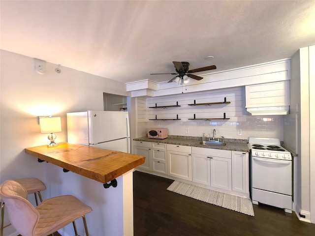 kitchen featuring butcher block countertops, white cabinetry, sink, a kitchen bar, and white appliances