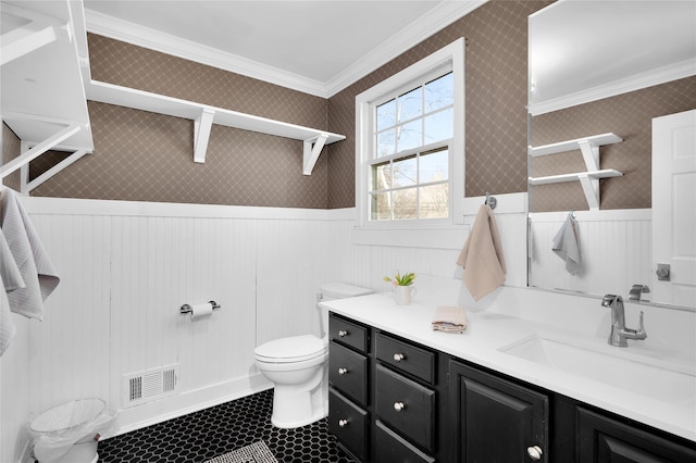 bathroom featuring a wainscoted wall, visible vents, crown molding, and toilet