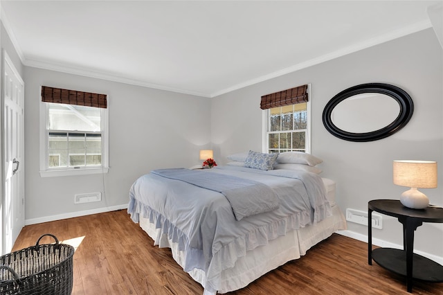 bedroom with ornamental molding, wood finished floors, visible vents, and baseboards