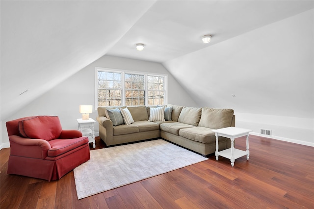 living room featuring vaulted ceiling, wood finished floors, visible vents, and baseboards