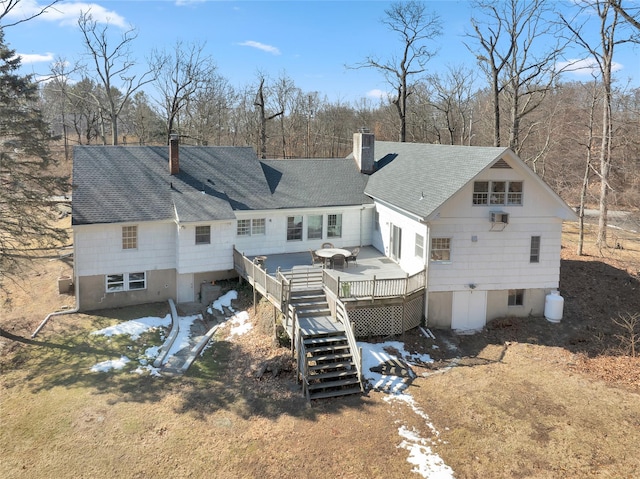 rear view of property with stairway, roof with shingles, a chimney, and a wooden deck