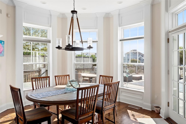 dining area featuring a notable chandelier, ornamental molding, and dark hardwood / wood-style floors