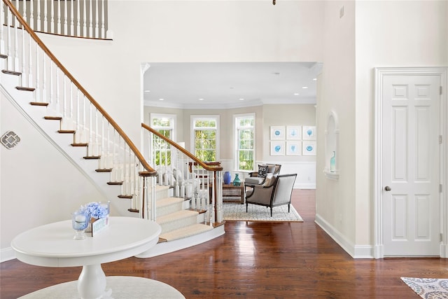 entryway featuring dark hardwood / wood-style flooring, crown molding, and a high ceiling