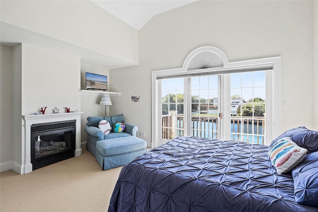 bedroom with carpet floors, access to outside, and high vaulted ceiling