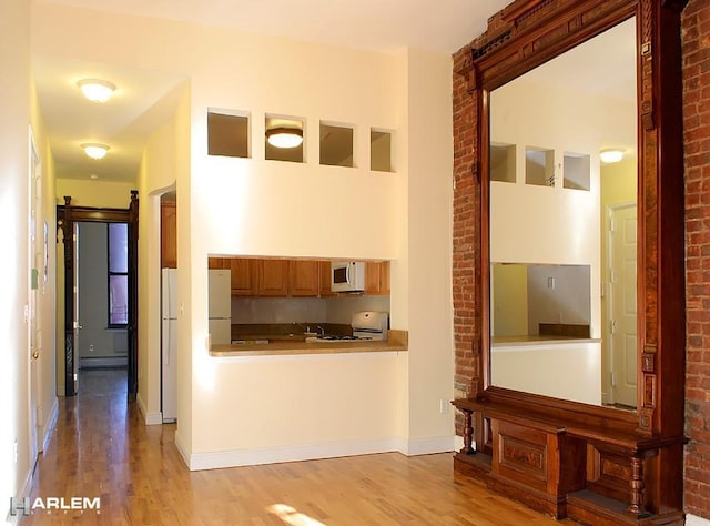 hallway featuring baseboard heating and light wood-type flooring