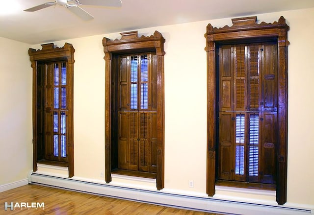 room details with ceiling fan, a baseboard radiator, and wood-type flooring