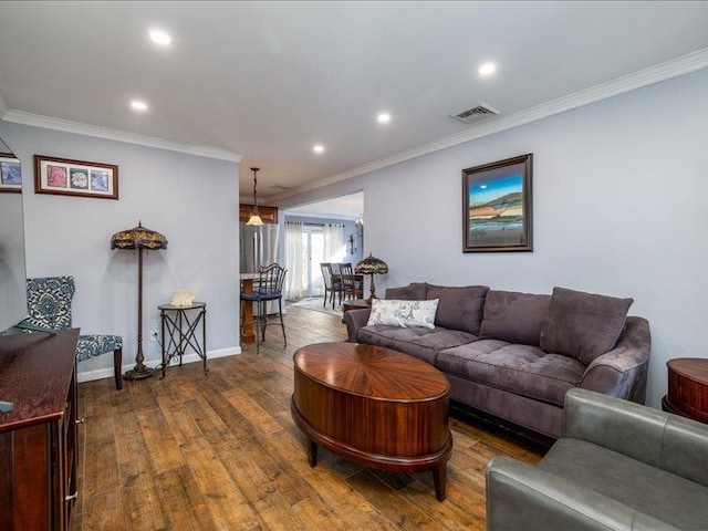 living room featuring wood-type flooring and crown molding