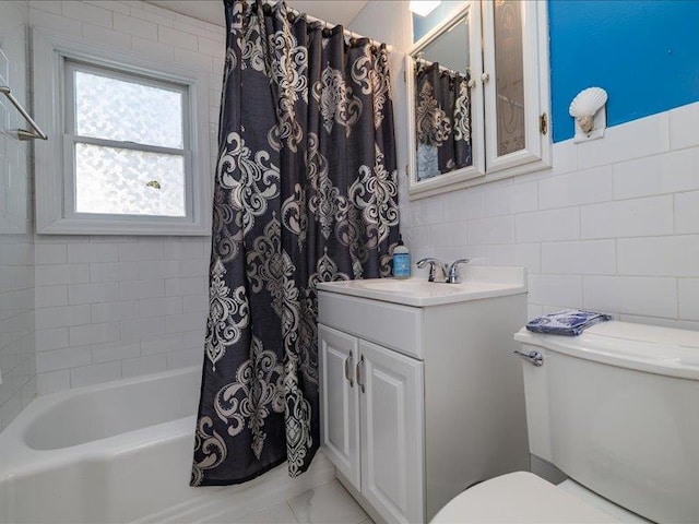 full bathroom with tile walls, vanity, toilet, and shower / tub combo with curtain