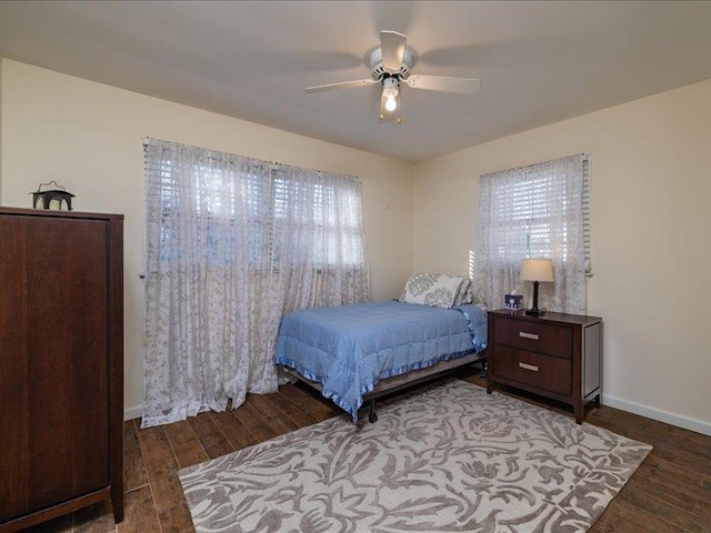 bedroom featuring multiple windows, dark hardwood / wood-style floors, and ceiling fan