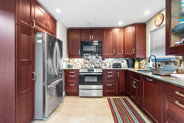 kitchen featuring light tile patterned flooring, tasteful backsplash, sink, dark stone counters, and stainless steel appliances