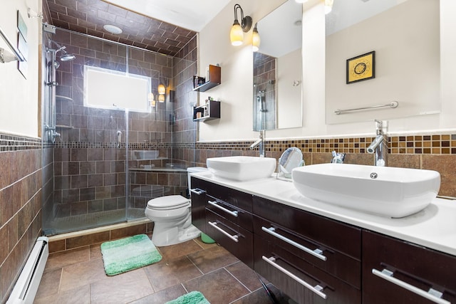 bathroom featuring a shower with shower door, a baseboard radiator, tile walls, vanity, and toilet