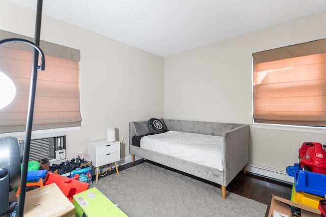 bedroom featuring wood-type flooring and a baseboard radiator