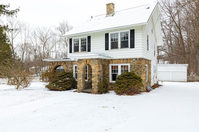 view of front facade with a garage and an outbuilding