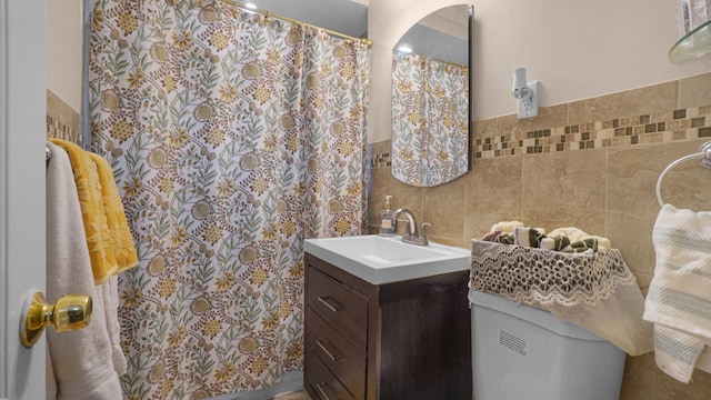 bathroom featuring vanity, tile walls, and toilet