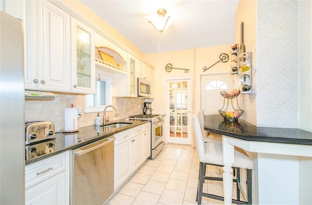 kitchen with stainless steel appliances, tasteful backsplash, sink, and white cabinets