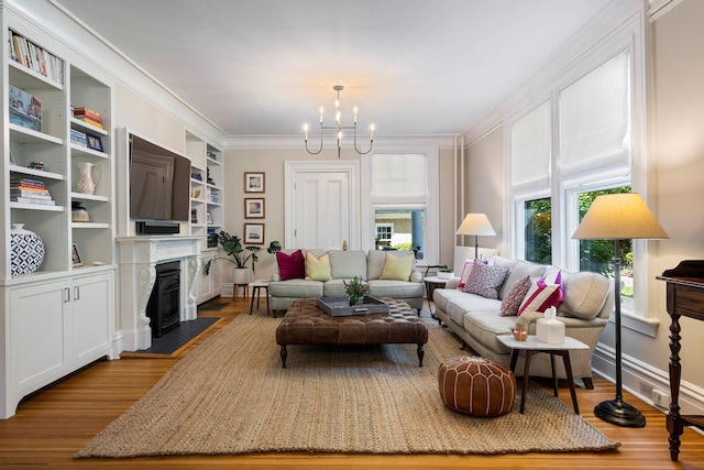 157 Merlin Ave, Sleepy Hollow, NY 10591 - living room featuring ornamental molding, a chandelier, wood finished floors, and a fireplace with flush hearth