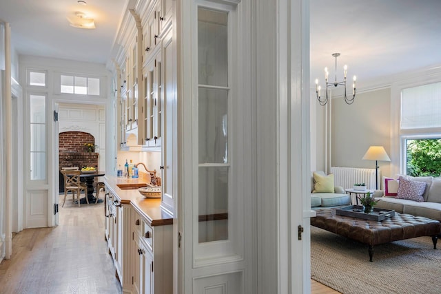 157 Merlin Ave, Sleepy Hollow, NY 10591 - corridor with light wood-style flooring and a chandelier