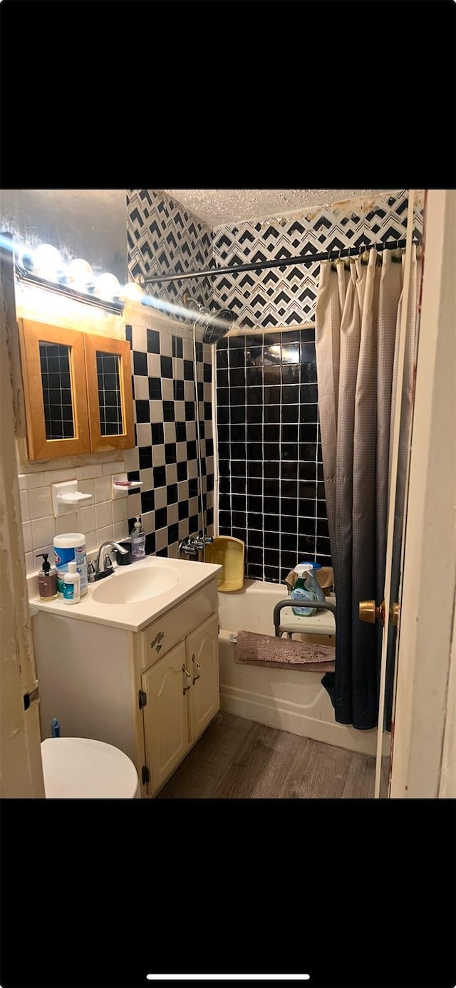 full bathroom featuring tile walls, backsplash, hardwood / wood-style flooring, vanity, and toilet