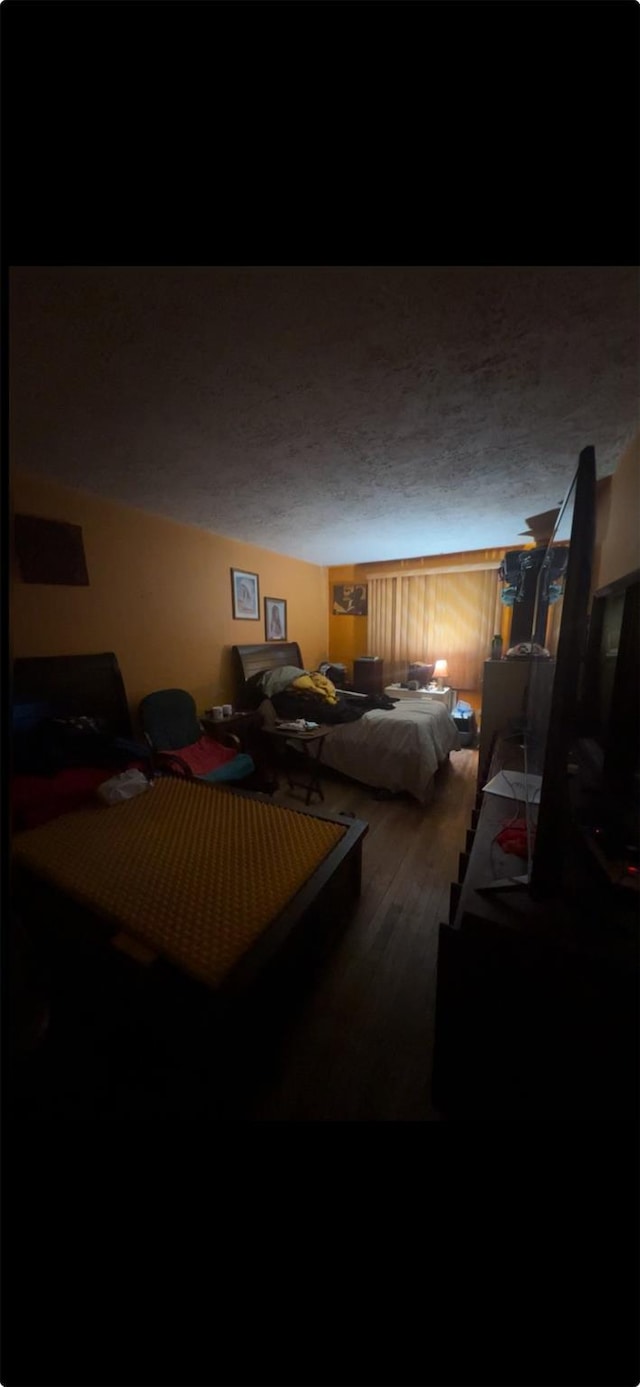 bedroom with wood-type flooring and a textured ceiling