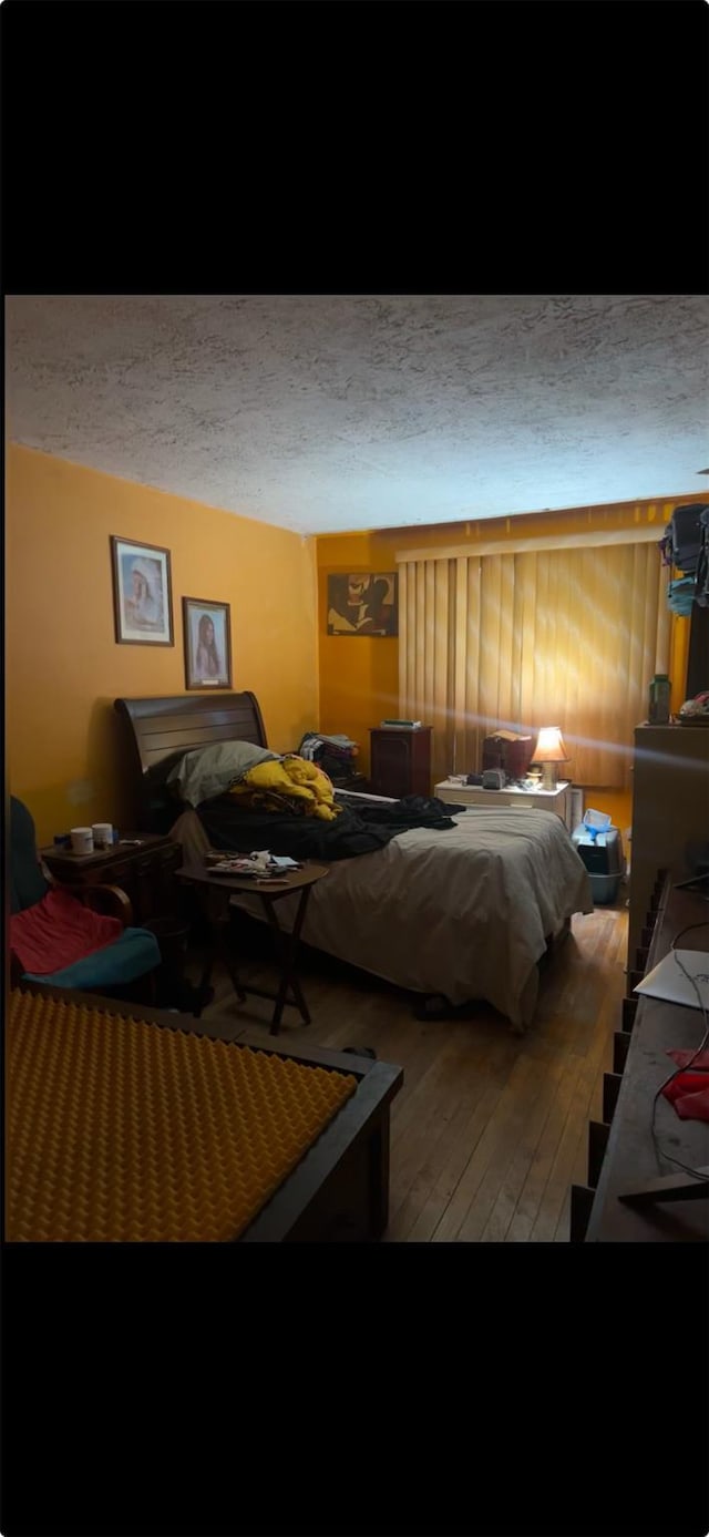 bedroom with hardwood / wood-style flooring and a textured ceiling