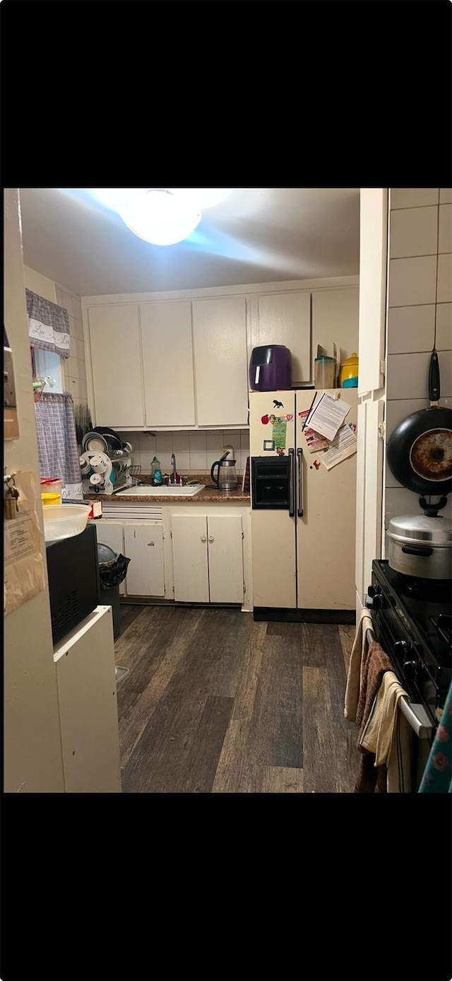 kitchen featuring white fridge with ice dispenser, sink, white cabinets, and dark hardwood / wood-style flooring