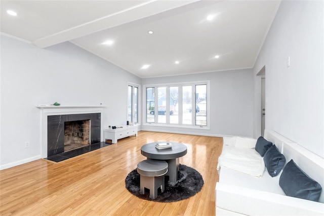 living room featuring hardwood / wood-style flooring, crown molding, and a tile fireplace