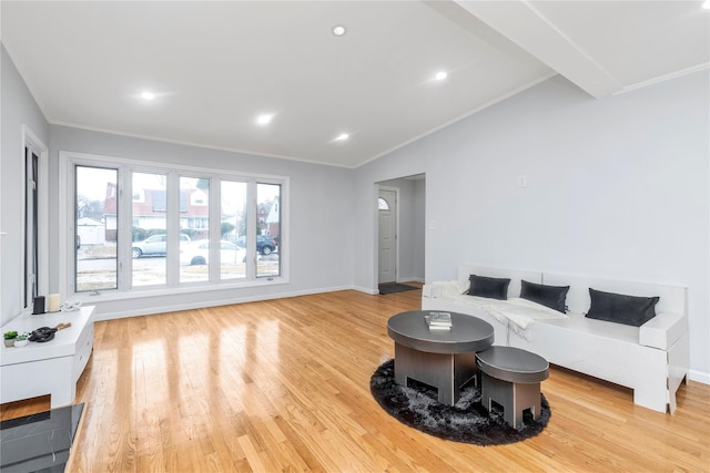 living room with crown molding, vaulted ceiling, and light hardwood / wood-style flooring