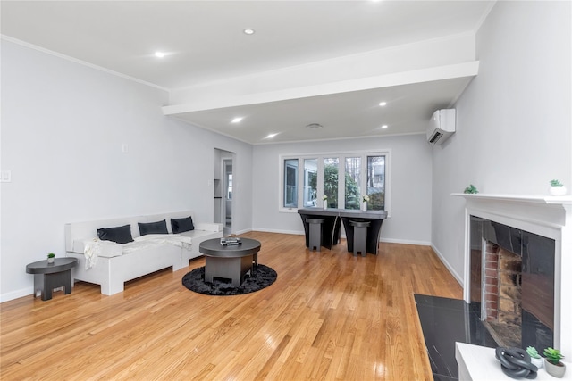 living room with crown molding, a wall mounted AC, a fireplace, and light hardwood / wood-style flooring