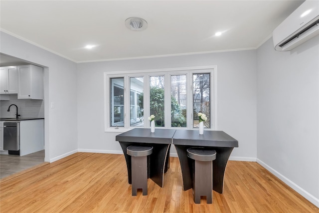 dining area with crown molding, a wall mounted air conditioner, sink, and light wood-type flooring