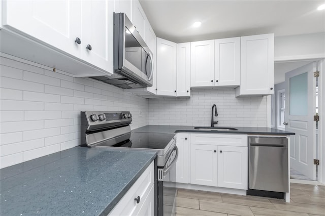 kitchen featuring white cabinetry, appliances with stainless steel finishes, sink, and backsplash