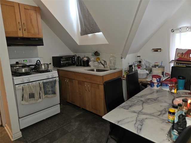 kitchen with vaulted ceiling, white gas range, sink, and decorative backsplash