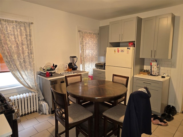 dining area featuring light tile patterned flooring and radiator heating unit