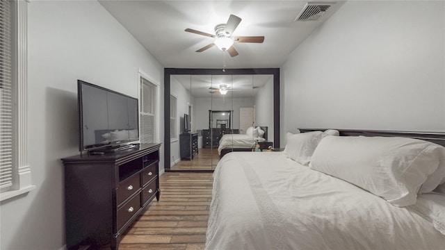 bedroom featuring ceiling fan, dark wood-style flooring, visible vents, and attic access