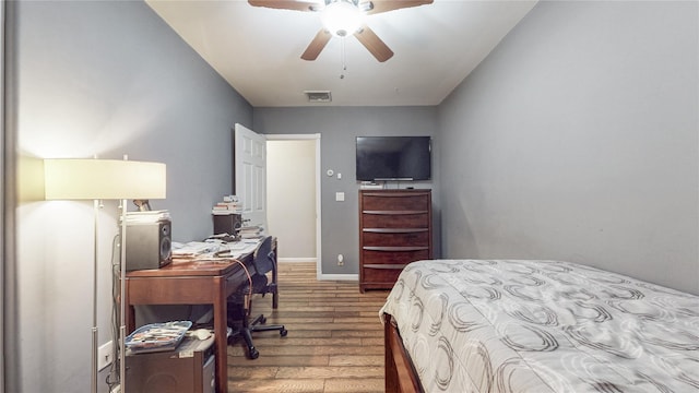 bedroom with baseboards, visible vents, ceiling fan, and wood finished floors