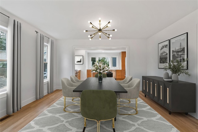 dining room with an inviting chandelier, light hardwood / wood-style flooring, and a healthy amount of sunlight