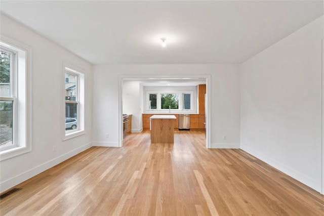 unfurnished living room featuring plenty of natural light and light wood-type flooring